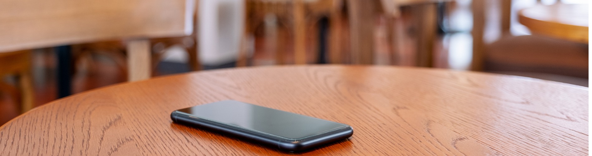 a-black-mobile-phone-on-the-table 1900x500